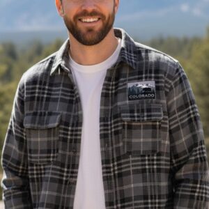A grey and black plaid flannel button-down shirt featuring an embroidered Colorado Mountain Brewery logo on the left chest pocket.