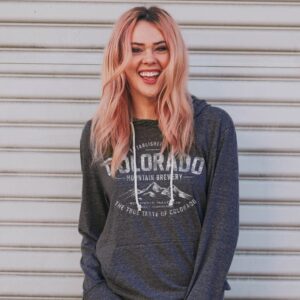 A heather navy pullover hoodie featuring a distressed white graphic of mountain peaks with "Established 2008" and "The True Taste of Colorado" text.